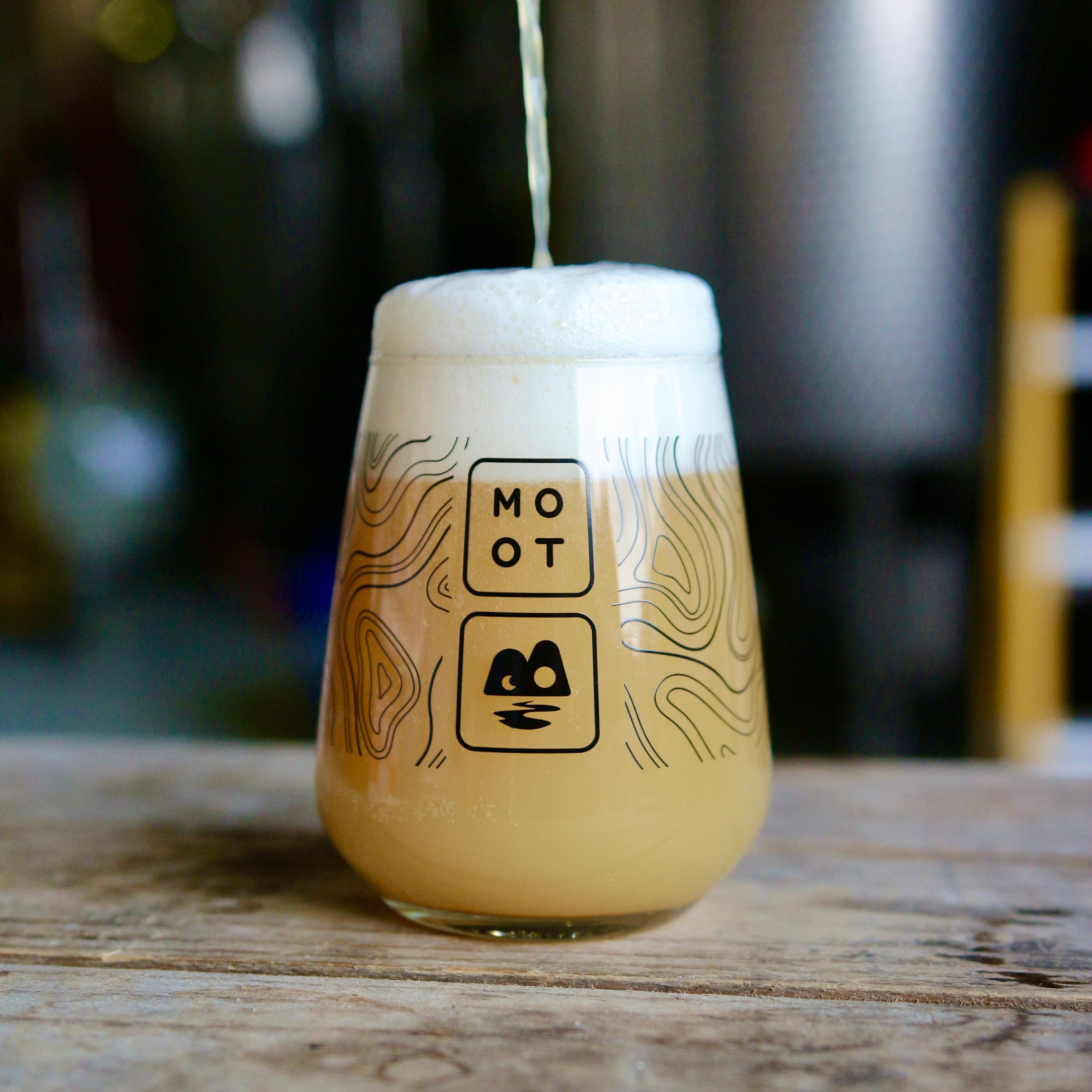 Golden hazy DIPA beer with thick white foam and tropical fruit aroma