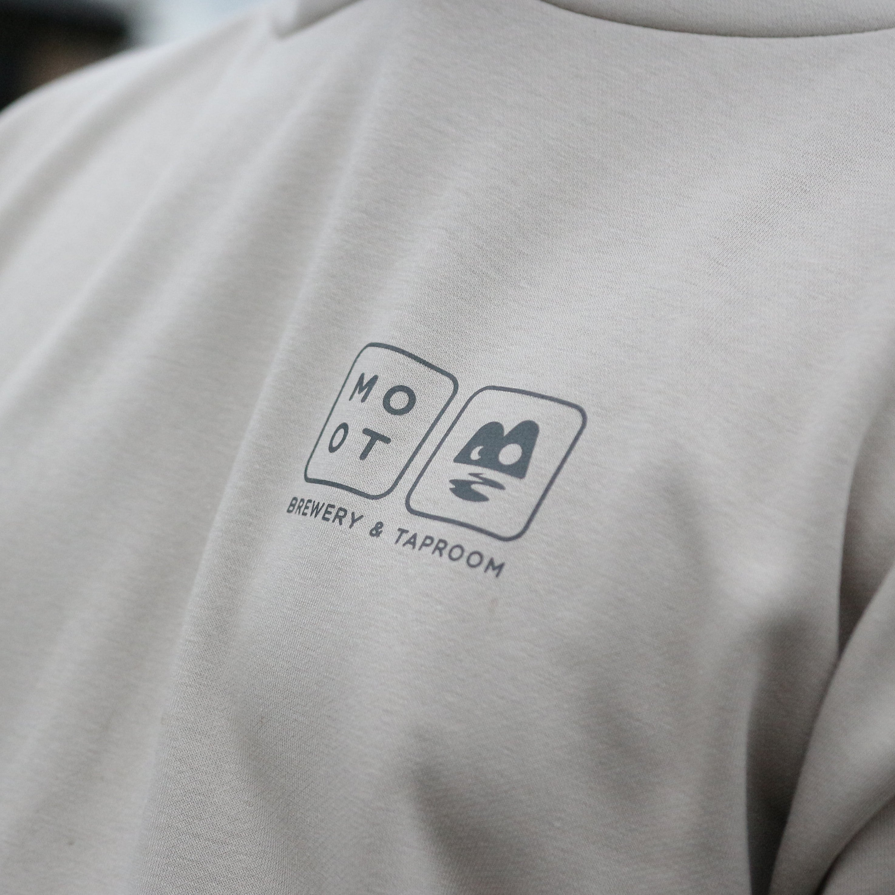 Beige hoodie with a logo on the chest