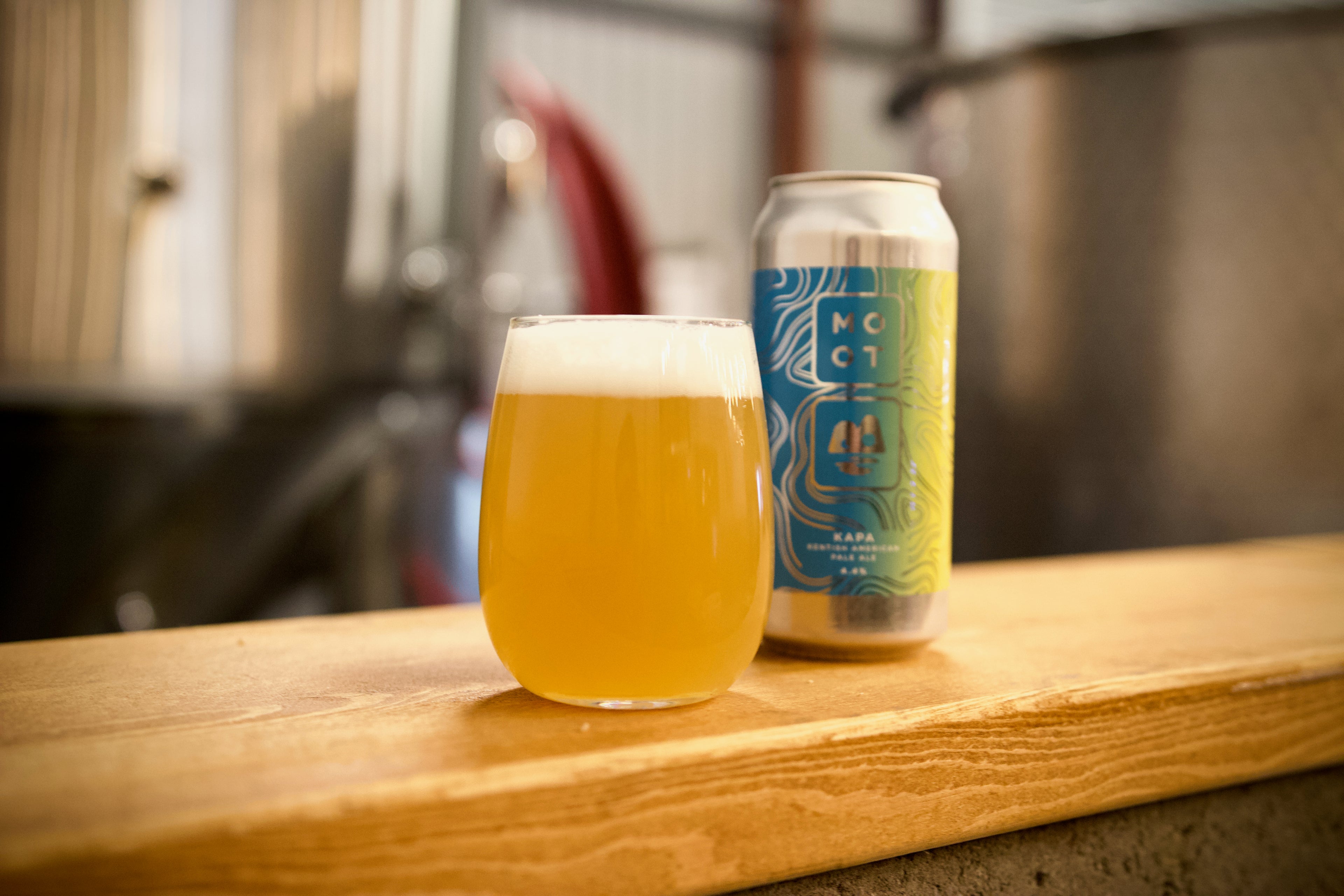 Hazy golden pale ale poured into glass with white foam and juicy aroma