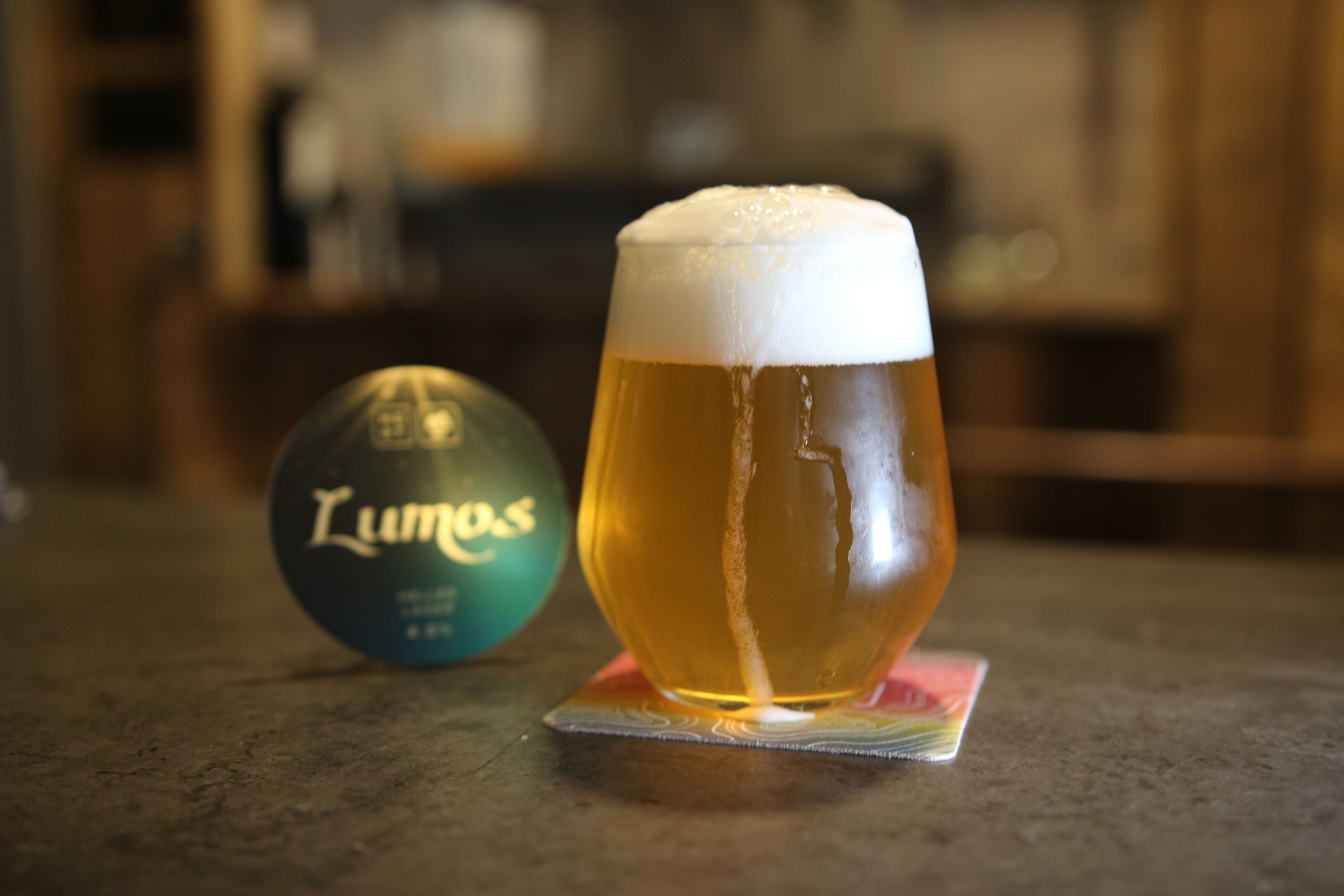 Golden Helles lager poured into glass with white foam and clear body