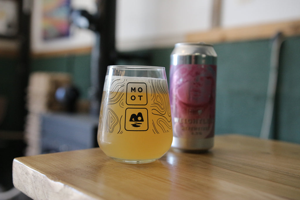 Cloudy golden Hefeweizen poured into tall glass with thick foam head